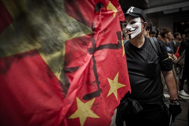 A man wears a mask of an anonymous hacker. (Photo Credit: PHILIPPE 
LOPEZ/AFP/GettyImages)
