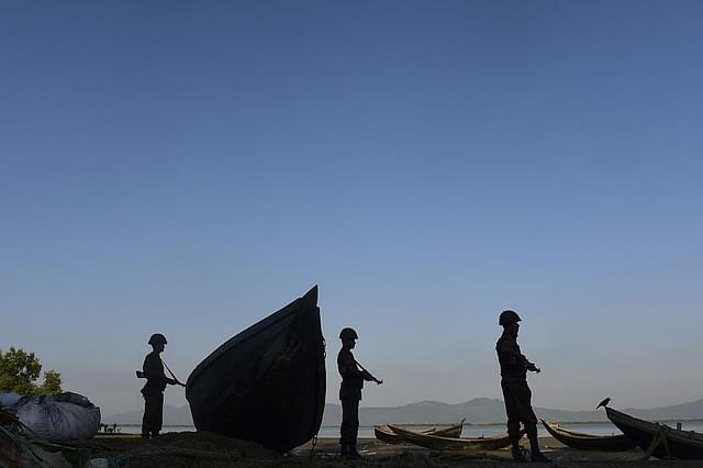Border Guard Bangladesh (BGB) personnel watching for the illegal entry of Myanmar Rohingya refugees on the banks of the Naf River. Photo credit: MUNIR UZ ZAMAN/AFP/Getty Images