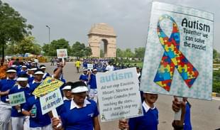 School children carry placards as they participate in the Autism Awareness Walk 2013.