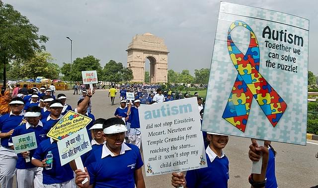 
School children carry placards as they participate in the Autism Awareness Walk 2013.
