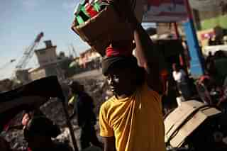 A man walks with merchandise he is trying to sell in Port-au-Prince, Haiti.  Photo credit: Spencer Platt/GettyImages