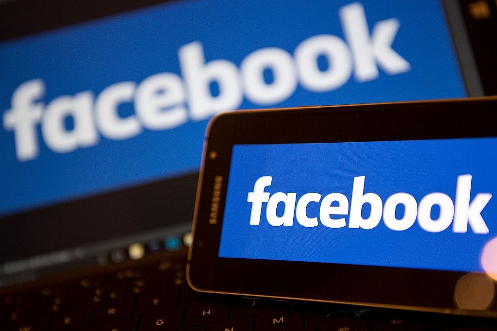 Facebook logos are pictured on the screens of a smartphone (R), and a laptop computer (Photo credit: JUSTIN TALLIS/AFP/Getty Images)