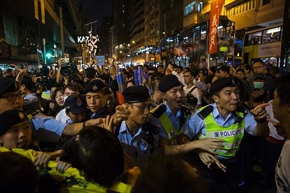 Police scuffling with protesters during an earlier demonstration against an expected interpretation of the Basic Law.