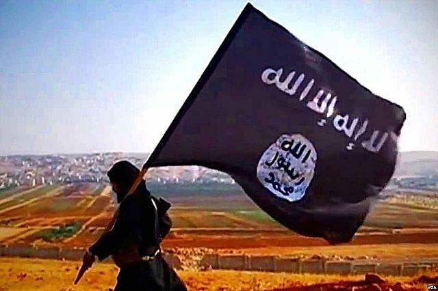 Islamic State fighter carrying their flag (Wikimedia Commons)