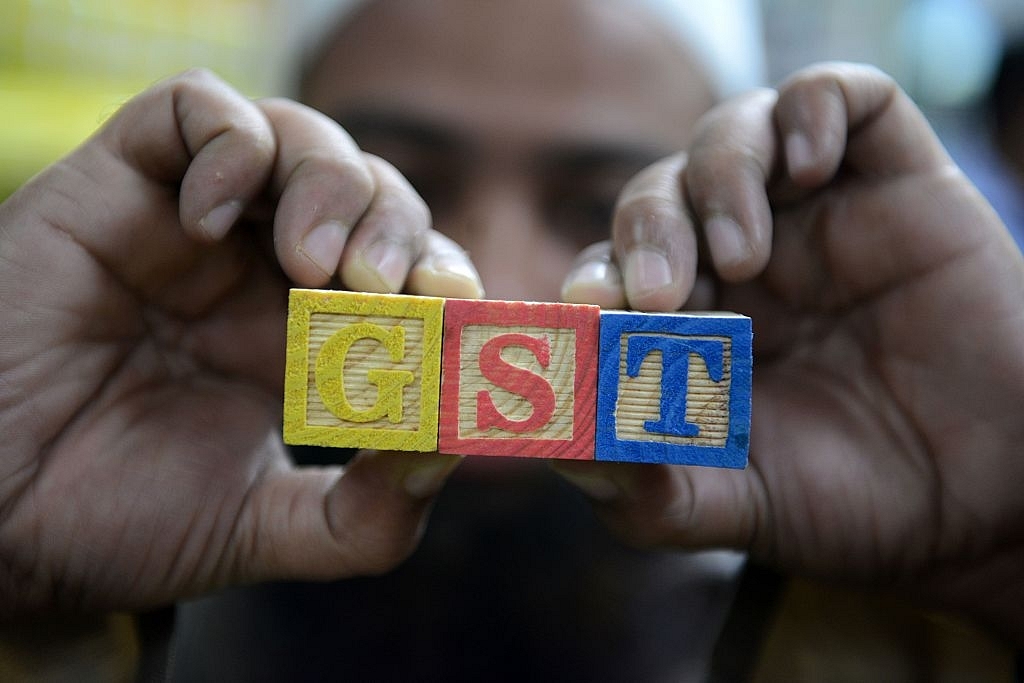 An Indian consumer goods trader shows letters GST representing ‘goods and services tax’.&nbsp; (NOAH SEELAM/AFP/Getty Images)