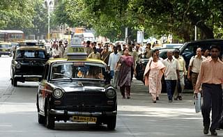  Indian commuters walk alongside taxis on the streets of Mumbai (ROB ELLIOTT/AFP/Getty Images)
