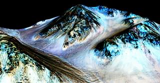In this handout provided by NASA’s Mars Reconnaissance Orbiter, dark, narrow streaks on the slopes of Hale Crater are inferred to be formed by seasonal flow of water on surface of present-day Mars. Photo credit: NASA/JPL-Caltech/Univ of Arizona via Getty Images