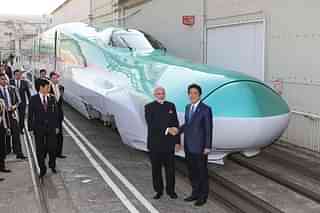 
Narendra Modi and Shinzo Abe shake hands in front of a shinkansen train. (JIJI PRESS/AFP/Getty Images)

