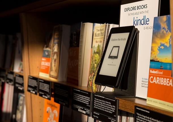 Books are displayed along side an Amazon
 Kindle device. Photo credit: Stephen Brashear/GettyImages