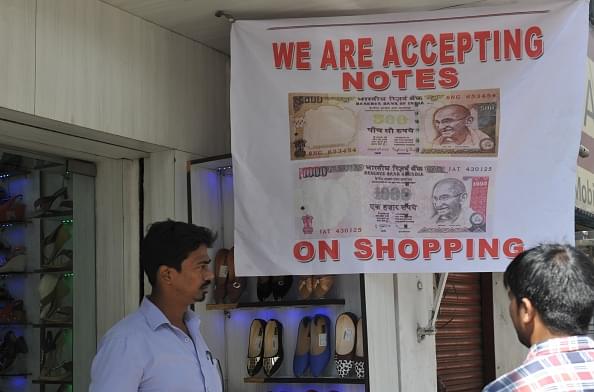 An Indian vendor displays a sign advertising acceptance of
banned Rs 500 and Rs 1,000 notes as he waits for customers at a shoe shop in
Hyderabad. Photo credit: NOAH SEELAM/AFP/GettyImages