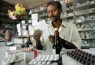 An Indian pharmacy shop assistant counts a strip of tablets. Photo credit: DESHAKALYAN CHOWDHURY/AFP/Getty Images