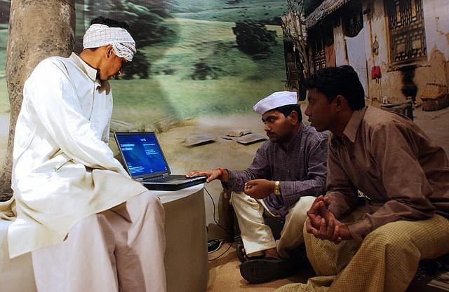 
Indian villagers work at a Panchayat console 
showcasing the theme of E-Governance. (MANPREET ROMANA/AFP/Getty Images)

