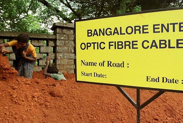 Workers dig up a trench before laying fibre optic cables in Bengaluru. (INDRANIL MUKHERJEE/AFP/Getty Images)