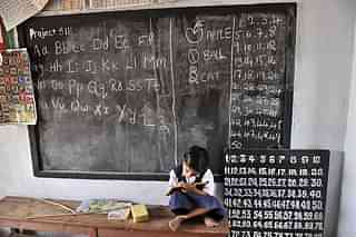 Indian school girl writes on a slate as she attends a government primary school in Hyderabad. Photo credit: NOAH SEELAM/AFP/Getty Images