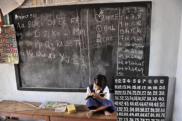 Indian school girl writes on a slate as she attends a government primary school in Hyderabad. Photo credit: NOAH SEELAM/AFP/Getty Images