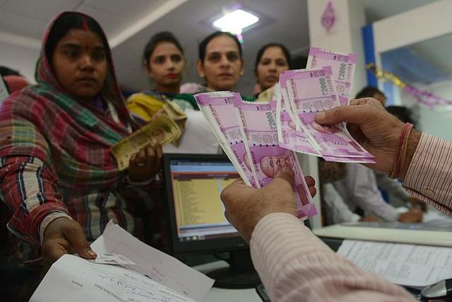 Customers at a bank counter exchanging old notes for new. (GettyImages)
