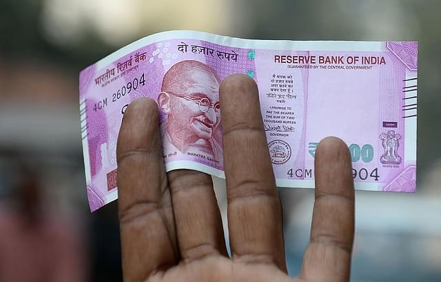 An Indian man displays a new Rs 2,000 note after exchanging his old Rs 500 and Rs 1,000 notes at a bank in New Delhi. (SAJJAD HUSSAIN/AFP/Getty Images) (representative picture)