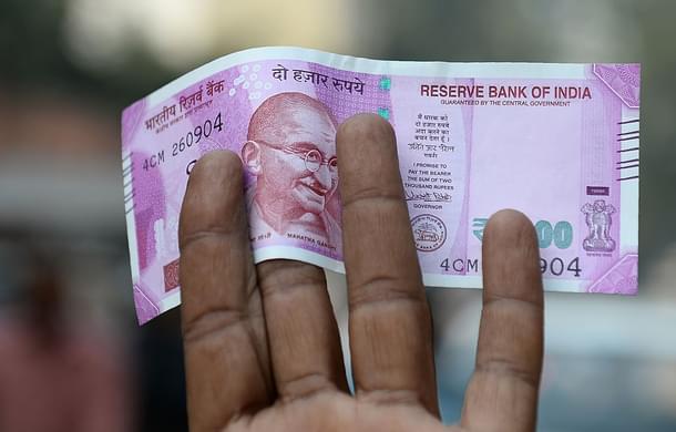 An Indian man displays a new Rs 2,000 note after exchanging his old Rs 500 and Rs 1,000 notes at a bank in New Delhi. (SAJJAD HUSSAIN/AFP/Getty Images)