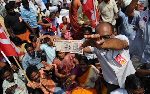 A man displays a Rs 1,000 note at a protest against the withdrawal of high-value banknotes from circulation (ARUN SANKAR/AFP/Getty Images)