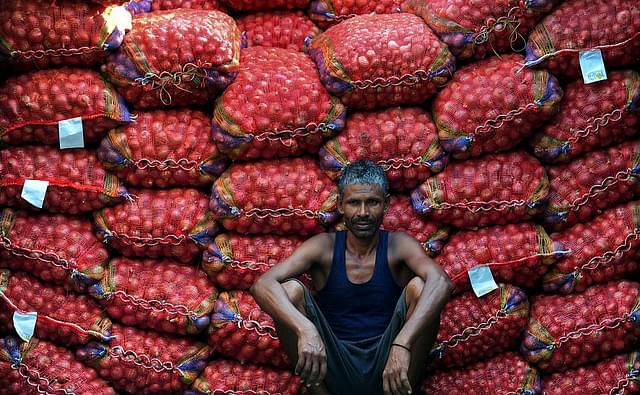 A labourer takes a break from unloading sacks of onions from a truck. (Sanjay Kanojia/AFP/Getty Images)