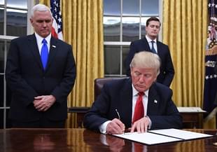US President Donald Trump signs an executive order as Vice President Mike Pence looks on at the White House in Washington, DC. (JIM WATSON/AFP/Getty Images)
