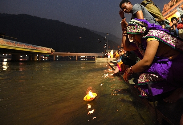 

A woman prays as she sets a diya afloat in the Ganges during celebrations of Diwali. (DOMINIQUE FAGET/AFP/GettyImages)