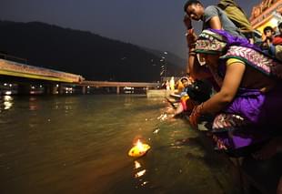 A woman prays as she sets a diya afloat in the Ganges during celebrations of Diwali. (DOMINIQUE FAGET/AFP/GettyImages)