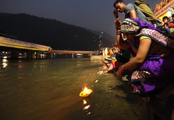 A woman prays as she sets a diya afloat in the Ganges during celebrations of Diwali. (DOMINIQUE FAGET/AFP/GettyImages)