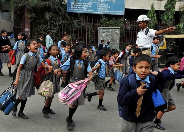 School children run
across a busy road as a traffic police stops the traffic in Bengaluru.
(DIBYANGSHU SARKAR/AFP/GettyImages) 