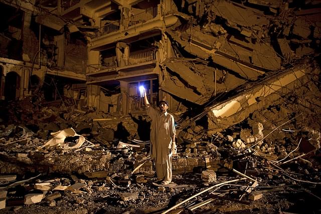 A man sifts through the rubble in the wake of a bomb blast in Peshawar, Pakistan, in 2009. (Paula Bronstein/Getty Images)
