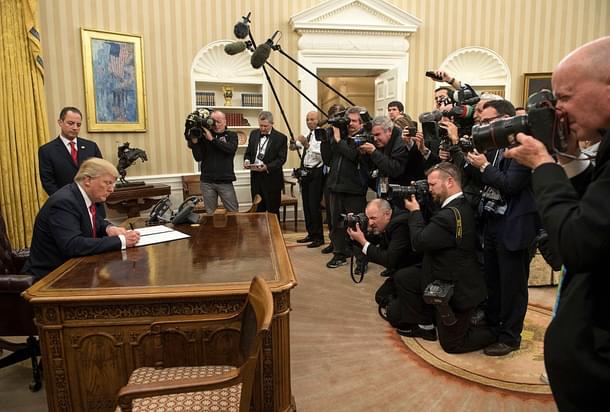 President Donald Trump signs his first executive order as president, ordering federal agencies to ease the burden of the Affordable Care Act. (Kevin Dietsch - Pool/Getty Images)