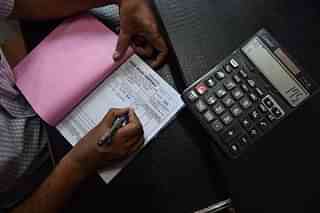 An Indian shopkeeper prepares a bill for a customer at his shop in New Delhi. (SAJJAD HUSSAIN/AFP/Getty Images)