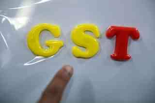 An Indian consumer goods trader shows letters GST at his shop in
Hyderabad.(NOAH SEELAM/AFP/GettyImages)