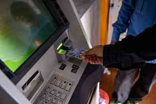 An Indian man inserts his card to
withdraw money from a mobile bank ATM machine in New Delhi. (CHANDAN
KHANNA/AFP/Gettymages)