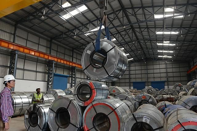 

Indian workers store steel coils unloaded at a new private freight terminal near Ahmedabad. (SAM PANTHAKY/AFP/GettyImages)