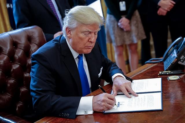 
US President Donald Trump signs an executive order related to the oil pipeline. (Shawn Thew-Pool/Getty Images)

