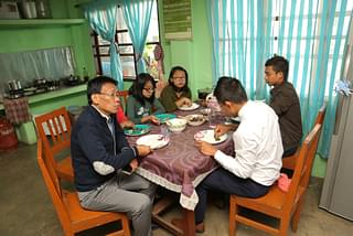 The pastor of Tangkhul Baptist Church in Imphal, Reverend Ngamlei Zimik (foreground, in dark blue cardigan), enjoying a five course meal with his family members at the pastor’s quarters inside the Church compound on December 25 noon. (Rajkumar Mixn)