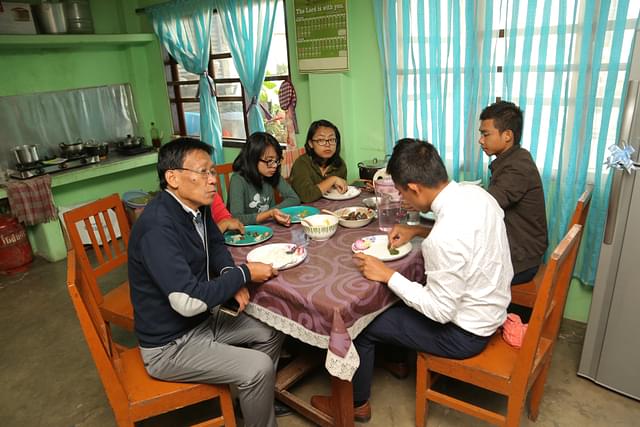 The pastor of Tangkhul Baptist Church in Imphal, Reverend Ngamlei Zimik (foreground, in dark blue cardigan), enjoying a five course meal with his family members at the pastor’s quarters inside the Church compound on December 25 noon. (Rajkumar Mixn)