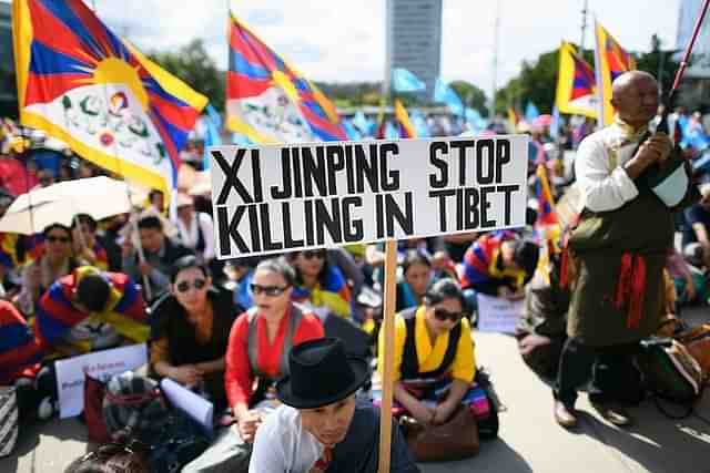 
A protester holds a placard reading ‘Xi Jinping stop killing in 
Tibet’ during a rally involving members of the Tibetan and Uyghur communities. (FABRICE COFFRINI/AFP/Getty 
Images)

