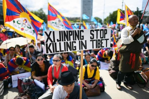 A protester holds a placard reading ‘Xi Jinping stop killing in 
Tibet’ during a rally involving members of the Tibetan and Uyghur communities. (FABRICE COFFRINI/AFP/Getty 
Images)