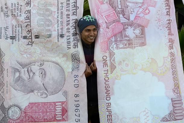 A man poses with replica prints of the demonetised Rs 500 and Rs 1,000 notes as part of a street art exhibition in Mumbai. (INDRANIL MUKHERJEE/AFP/Getty Images)