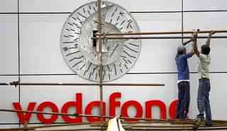 Workers put up the signboard of Vodafone at their corporate office in Mumbai. (SAJJAD HUSSAIN/AFP/GettyImages) <br>