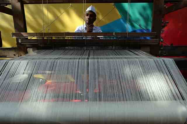 An artisan weaves traditional khadi cloth on a handloom. Photo credit RAKASH SINGH/AFP/Getty Images)