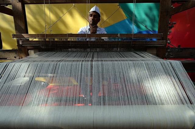 An artisan weaves traditional khadi cloth on a handloom. (Photo credit RAKASH SINGH/AFP/Getty Images)