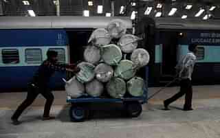 Indian railways workers use a cart to transport goods through a train station in Chennai. (ARUN SANKAR/AFP/Getty Images)