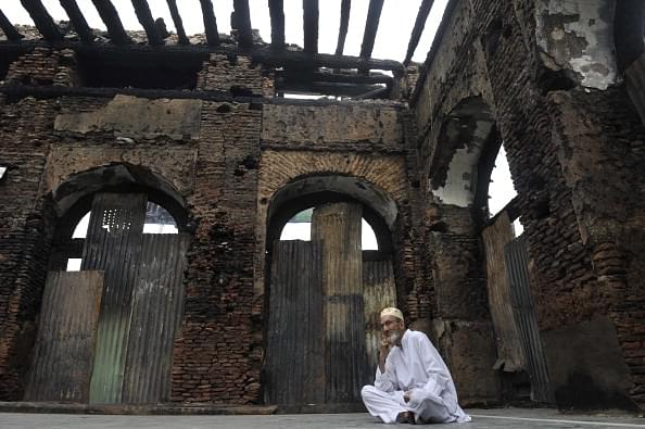 A Kashmiri Muslim sits next to the ruins of a revered 200-year old sufi shrine in Srinagar. (Representative Image | TAUSEEF MUSTAFA/AFP/GettyImages)