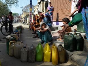 A child sits with others as they wait their turn to get subsidsed kerosene oil  outside a government fair price shop in Alwar district of Rajashtan. (SAJJAD HUSSAIN/AFP/GettyImages)