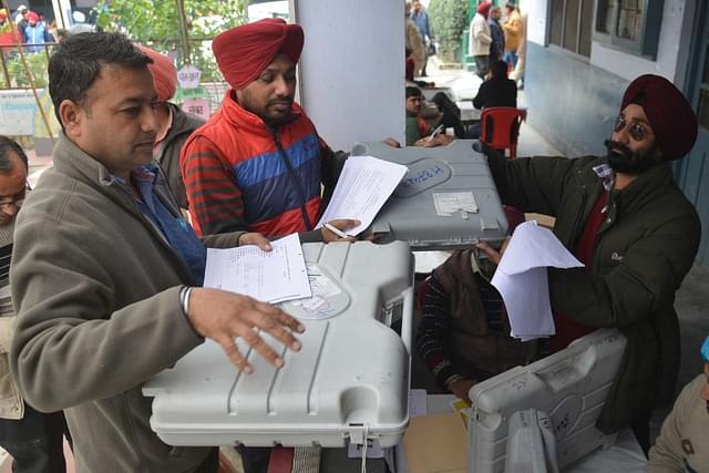 Poll officials carry Electronic Voting Machines in Amritsar. (NARINDER NANU/AFP/Getty Images)