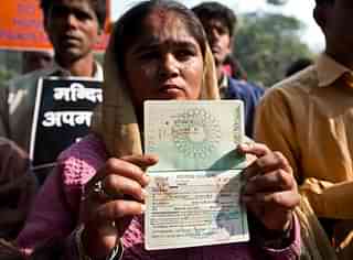 A Hindu refugee from Pakistan shows her now-expired Indian visa page on her passport during a demonstration. (PRAKASH SINGH/AFP/Getty Images)