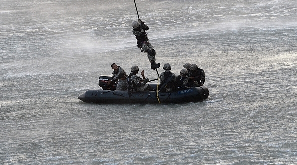 

Marine Commandos (MARCOS) of the Indian Navy take part in a simulated hostage rescue operation at The Gateway of India. (INDRANIL MUKHERJEE/AFP/Getty Images)